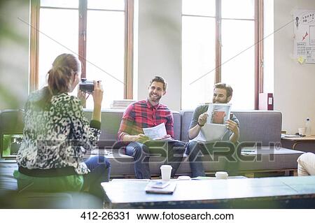 Creative businessman posing with photograph for coworker with instant camera in office View Large Photo Image Stock Image - Creative businessman posing with photograph for coworker with instant camera in office. Fotosearch