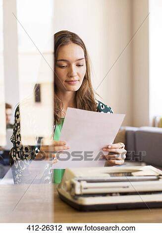 Creative businesswoman reviewing paperwork at typewriter in office View Large Photo Image Stock Image - Creative businesswoman reviewing paperwork at typewriter in office. Fotosearch