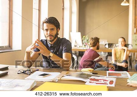 Stock Photography - Portrait confident creative businessman working with proofs in office. Fotosearch