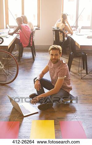 Portrait creative businessman working on laptop on floor View Large Photo Image Picture - Portrait creative businessman working on laptop on floor. Fotosearch