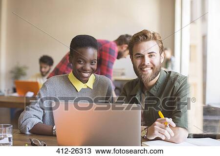 Portrait smiling business people working at laptop in office View Large Photo Image Stock Image - Portrait smiling business people working at laptop in office. Fotosearch