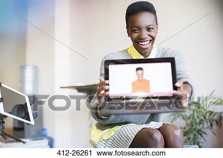 Portrait smiling businesswoman showing photograph of self on laptop View Large Photo Image Stock Image - Portrait smiling businesswoman showing photograph of self on laptop. Fotosearch