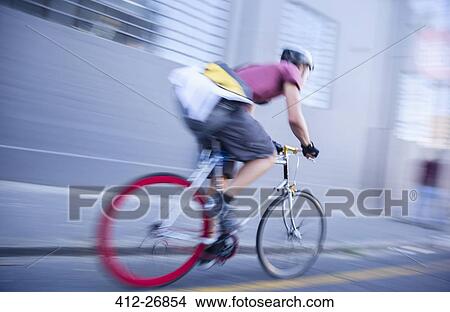 Bicycle messenger speeding down urban street View Large Photo Image Picture - Bicycle messenger speeding down urban street. Fotosearch