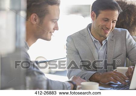 Businessmen with coffee working at laptop in cafe View Large Photo Image Stock Image - Businessmen with coffee working at laptop in cafe. Fotosearch