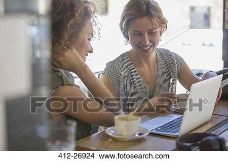 Businesswomen with coffee working at laptop in cafe View Large Photo Image Picture - Businesswomen with coffee working at laptop in cafe. Fotosearch