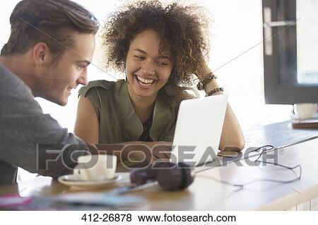 Couple sharing laptop in cafe View Large Photo Image Stock Photo - Couple sharing laptop in cafe. Fotosearch