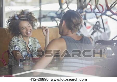 Stock Image - Couple talking at cafe table. Fotosearch