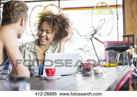 Couple talking at laptop in cafe View Large Photo Image Stock Photography - Couple talking at laptop in cafe. Fotosearch