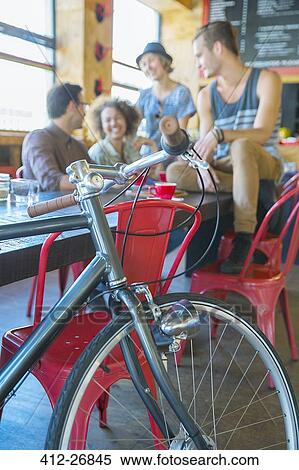 Friends hanging out at cafe behind bicycle View Large Photo Image Stock Photography - Friends hanging out at cafe behind bicycle. Fotosearch