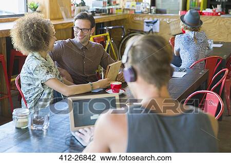 Friends sharing digital tablet in cafe View Large Photo Image Stock Image - Friends sharing digital tablet in cafe. Fotosearch