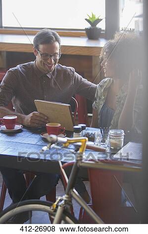 Friends sharing digital tablet in cafe View Large Photo Image Stock Photo - Friends sharing digital tablet in cafe. Fotosearch