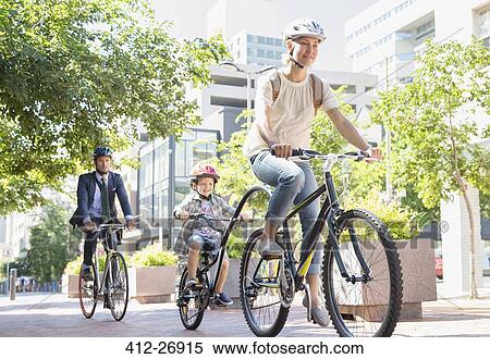 Mother and son in helmets riding tandem bicycle in urban park View Large Photo Image Stock Photography - Mother and son in helmets riding tandem bicycle in urban park. Fotosearch