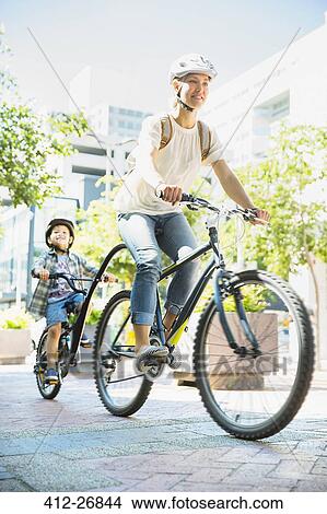 Mother and son riding bicycles on urban path View Large Photo Image Picture - Mother and son riding bicycles on urban path. Fotosearch