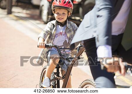 Portrait smiling boy riding bicycle on sunny road View Large Photo Image Stock Image - Portrait smiling boy riding bicycle on sunny road. Fotosearch