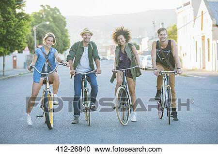 Portrait smiling friends sitting on bicycles on road View Large Photo Image Stock Image - Portrait smiling friends sitting on bicycles on road. Fotosearch