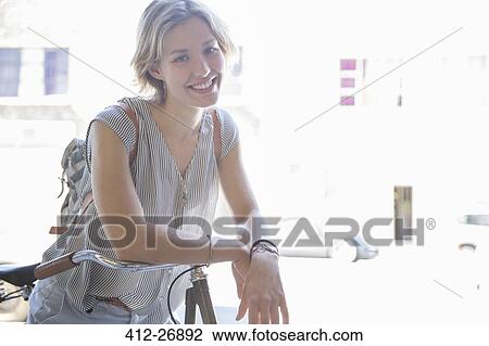 Portrait smiling woman on bicycle View Large Photo Image Stock Image - Portrait smiling woman on bicycle. Fotosearch