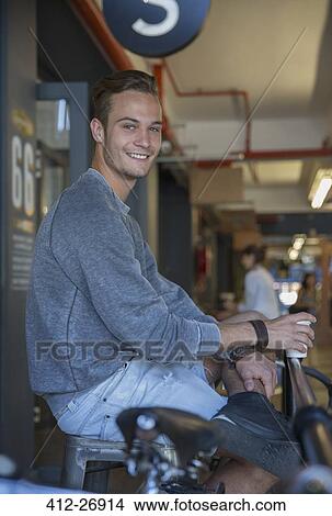 Picture - Portrait smiling young man drinking coffee at cafe. Fotosearch