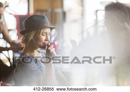 Woman in hat drinking coffee in cafe View Large Photo Image Stock Photography - Woman in hat drinking coffee in cafe. Fotosearch