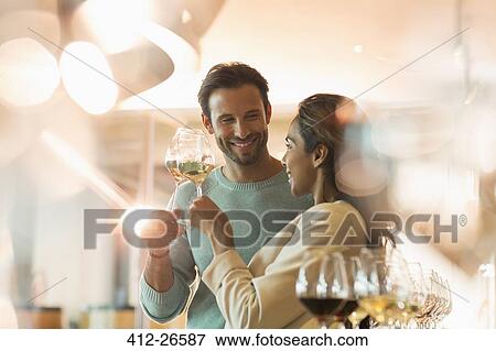 Couple wine tasting in sunny winery tasting room View Large Photo Image Stock Photo - Couple wine tasting in sunny winery tasting room. Fotosearch
