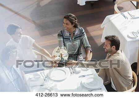 Friends toasting wine glasses at restaurant table View Large Photo Image Stock Image - Friends toasting wine glasses at restaurant table. Fotosearch