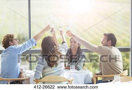 Friends toasting wine glasses overhead at winery dining room table View Large Photo Image Stock Image - Friends toasting wine glasses overhead at winery dining room table. Fotosearch