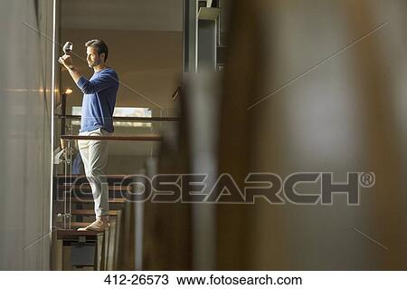 Man examining red wine on platform in winery cellar View Large Photo Image Stock Image - Man examining red wine on platform in winery cellar. Fotosearch