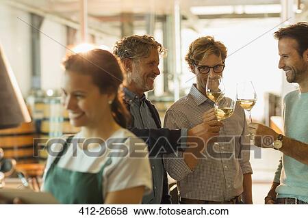 Men wine tasting white wine in winery tasting room View Large Photo Image Stock Photo - Men wine tasting white wine in winery tasting room. Fotosearch
