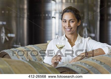Portrait confident vintner drinking white wine in winery cellar View Large Photo Image Stock Photo - Portrait confident vintner drinking white wine in winery cellar. Fotosearch