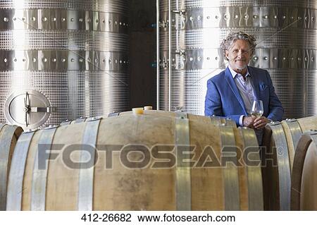 Stock Image - Portrait confident vintner in winery cellar. Fotosearch