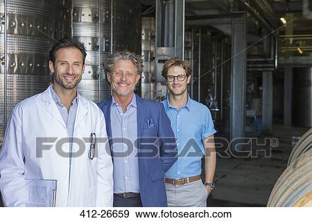 Portrait confident vintners in winery cellar View Large Photo Image Stock Photo - Portrait confident vintners in winery cellar. Fotosearch