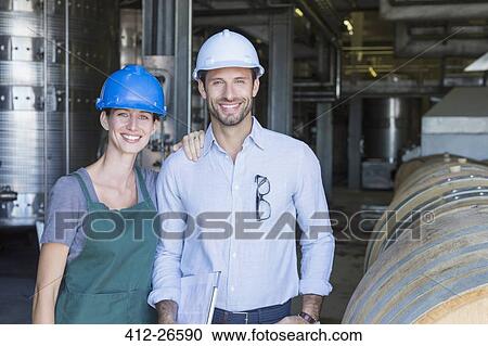 Portrait confident winery employees in hard hats in cellar View Large Photo Image Stock Image - Portrait confident winery employees in hard hats in cellar. Fotosearch