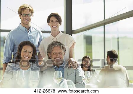 Stock Photo - Portrait smiling friends in sunny restaurant. Fotosearch