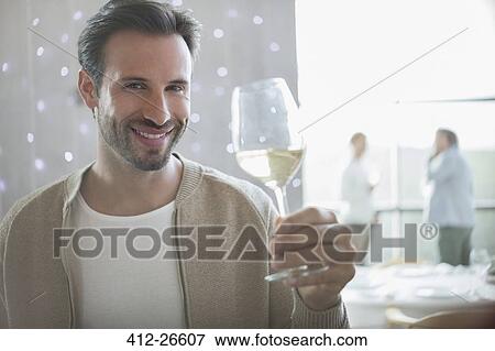 Stock Photo - Portrait smiling man drinking white wine in restaurant. Fotosearch