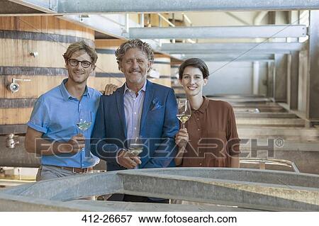 Portrait smiling vintners with white wine in winery cellar View Large Photo Image Stock Photo - Portrait smiling vintners with white wine in winery cellar. Fotosearch