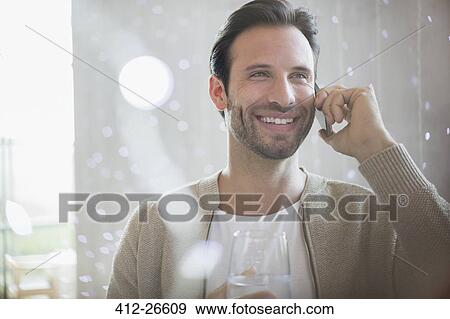 Smiling man drinking water and talking on cell phone View Large Photo Image Stock Photo - Smiling man drinking water and talking on cell phone. Fotosearch