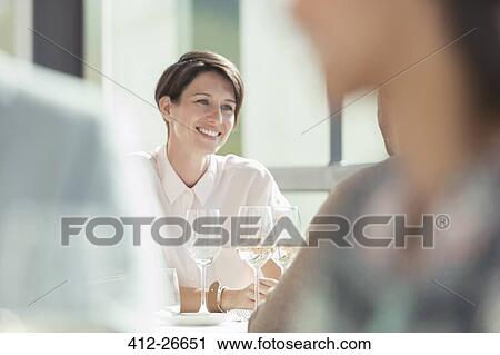Smiling woman drinking white wine in sunny restaurant View Large Photo Image Stock Image - Smiling woman drinking white wine in sunny restaurant. Fotosearch