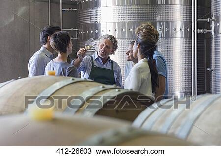 Vintner and winery employees examining wine in cellar View Large Photo Image Stock Image - Vintner and winery employees examining wine in cellar. Fotosearch