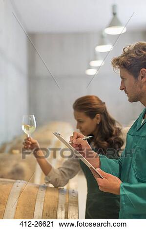 Vintners examining white wine in winery cellar View Large Photo Image Stock Image - Vintners examining white wine in winery cellar. Fotosearch
