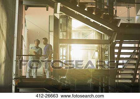 Vintners talking on platform in winery View Large Photo Image Stock Image - Vintners talking on platform in winery. Fotosearch