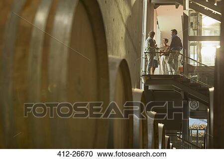 Vintners talking on platform in winery cellar View Large Photo Image Stock Image - Vintners talking on platform in winery cellar. Fotosearch