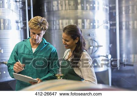 Stock Photo - Vintners with clipboard in winery cellar. Fotosearch