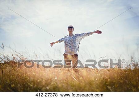 Carefree senior woman running with arms outstretched in sunny field View Large Photo Image Stock Photo - Carefree senior woman running with arms outstretched in sunny field. Fotosearch