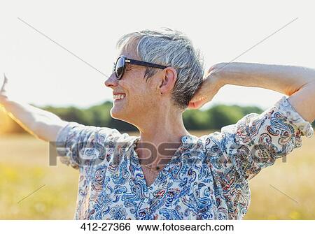 Enthusiastic senior woman with arms outstretched in sunny field View Large Photo Image Stock Photograph - Enthusiastic senior woman with arms outstretched in sunny field. Fotosearch
