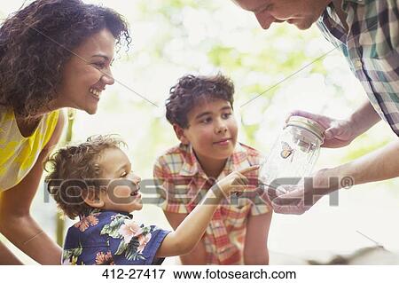 Family watching butterfly in jar View Large Photo Image Stock Photo - Family watching butterfly in jar. Fotosearch