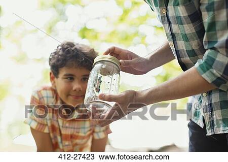 Father and son watching butterfly in jar View Large Photo Image Stock Image - Father and son watching butterfly in jar. Fotosearch