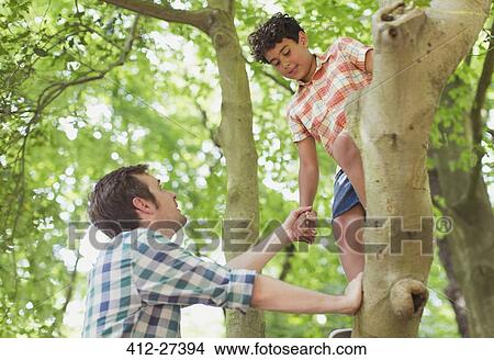 Father helping son climbing tree View Large Photo Image Picture - Father helping son climbing tree. Fotosearch