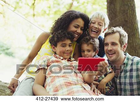 Multi-generation family taking selfie with camera phone in woods View Large Photo Image Stock Photo - Multi-generation family taking selfie with camera phone in woods. Fotosearch
