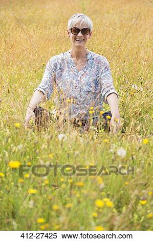 Portrait senior woman sitting cross-legged in rural field View Large Photo Image Stock Photography - Portrait senior woman sitting cross-legged in rural field. Fotosearch