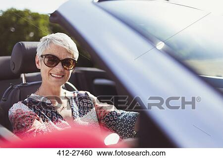 Portrait smiling senior woman in sunglasses driving convertible View Large Photo Image Stock Image - Portrait smiling senior woman in sunglasses driving convertible. Fotosearch