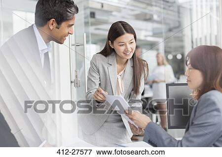 Business people discussing paperwork in office View Large Photo Image Stock Photo - Business people discussing paperwork in office. Fotosearch